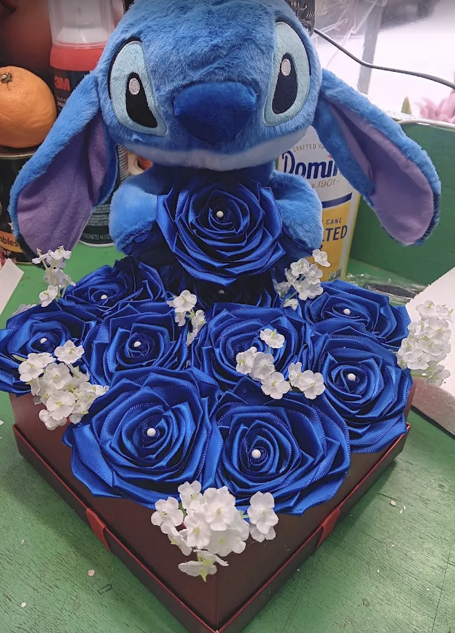 Blue satin roses in a box with a Stitch plush