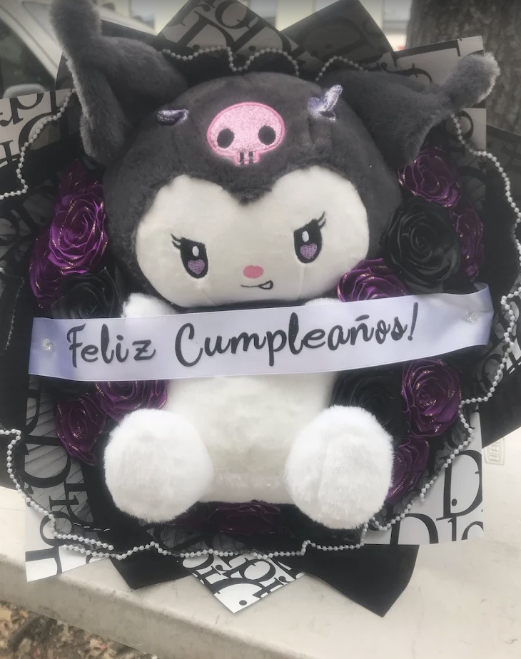 Kuromi plush surrounded by purple and black roses with a birthday sash