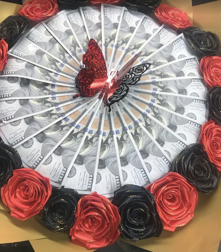 Money fan arrangement framed with red and black satin roses